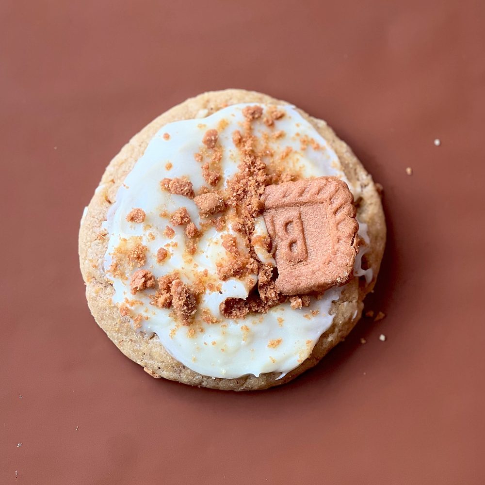 MELT. Biscoff & Cream cookie, topped with cream cheese icing, Biscoff crumbs and half a Lotus Biscoff biscuit, on brown paper
