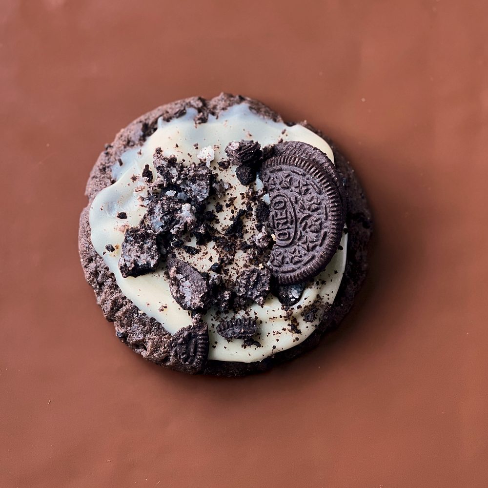 MELT. Oreo & Cream cookie, topped with cream cheese icing, Oreo crumbs and an Oreo biscuit, on brown paper